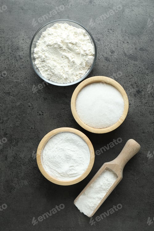 Preview: Baking powder and other ingredients for making dough on grey table, flat lay