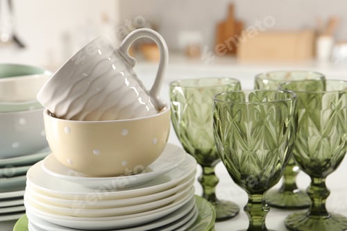 Preview: Many different clean dishware, glasses and cup on table indoors, closeup