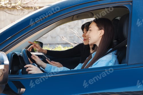 Preview: Woman driving car and her friend with smartphone navigating, view through window