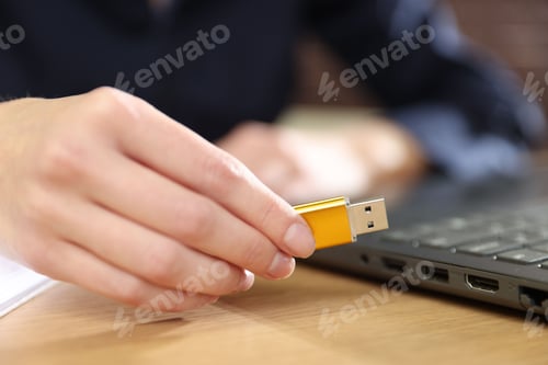 Preview: Woman with USB flash drive at wooden desk, closeup