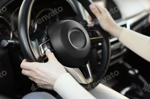 Preview: Woman behind steering wheel of modern car, closeup