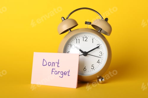 Preview: Alarm clock and sticky note with phrase Don't forget on yellow background. Space for text