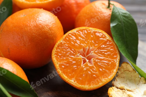 Preview: Fresh tangerines and green leaves on wooden table, closeup