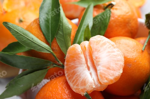 Preview: Fresh tangerines and green leaves in bowl on table, closeup