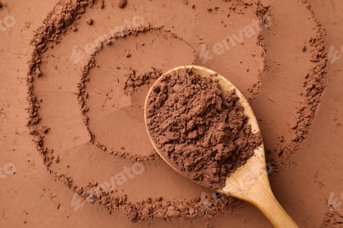 Preview: Cocoa powder and wooden spoon as background, top view