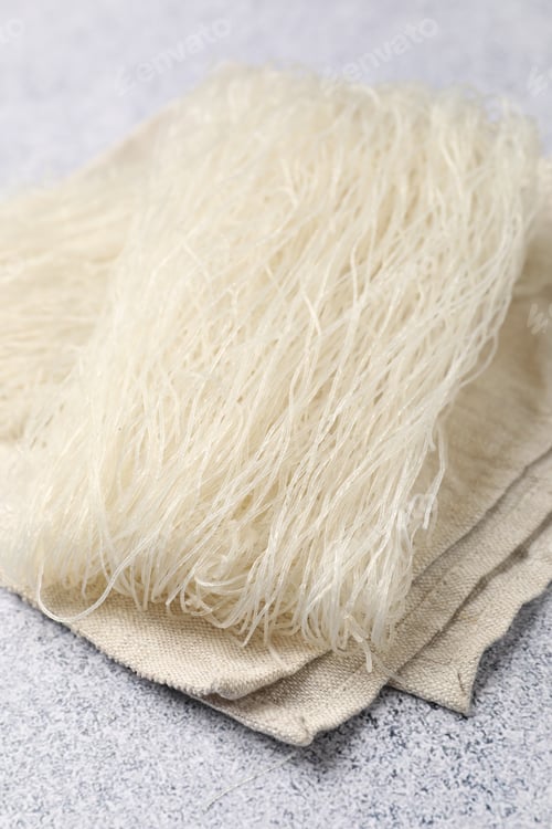 Preview: Uncooked rice noodles on grey table, closeup