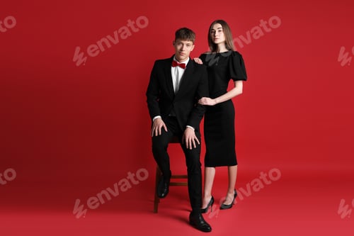Preview: Happy couple in stylish clothes on red background