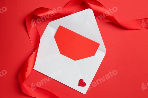 Preview: Envelope with love letter and ribbon on red background, top view