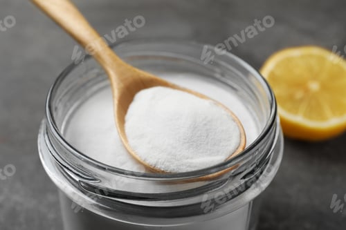 Preview: Baking soda, spoon and lemon on grey table, closeup