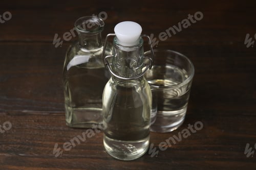 Preview: Vinegar in bottles and glass on wooden table