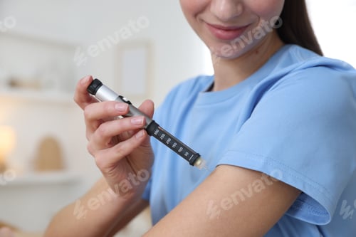 Preview: Diabetes. Woman making insulin injection into her arm with autoinjector indoors, closeup