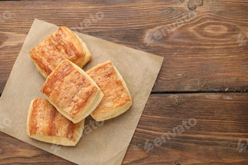 Preview: Tasty puff pastries on wooden table, top view. Space for text