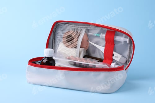 Preview: First aid kit. Different medical supplies in bag on light blue background, closeup