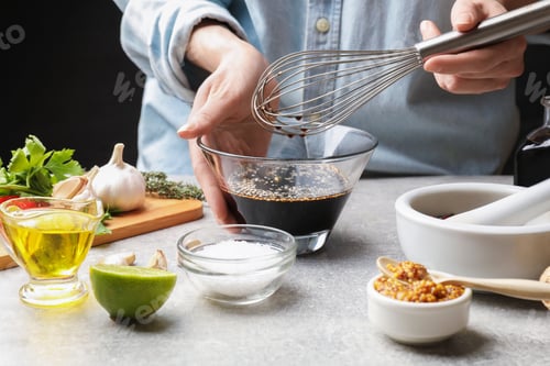 Preview: Woman mixing soy sauce for marinade at gray textured table, closeup