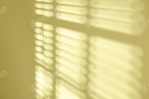 Preview: Light and shadows from window blinds falling on green wall, closeup