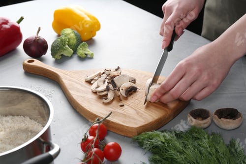 Preview: Healthy food. Woman cutting champignon at grey table, closeup