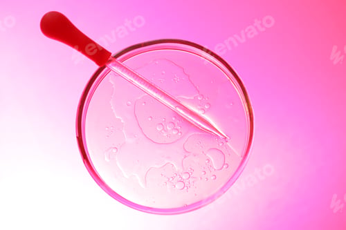 Preview: Dripping liquid from pipette into Petri dish on pink background, top view