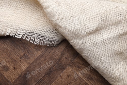 Preview: Natural burlap fabric on wooden table, top view. Space for text
