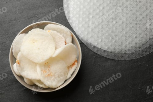 Preview: Rice paper chips and sheets on black textured table, flat lay