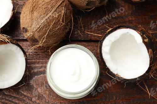 Preview: Tasty coconut yogurt in jar and fruits on wooden table, flat lay