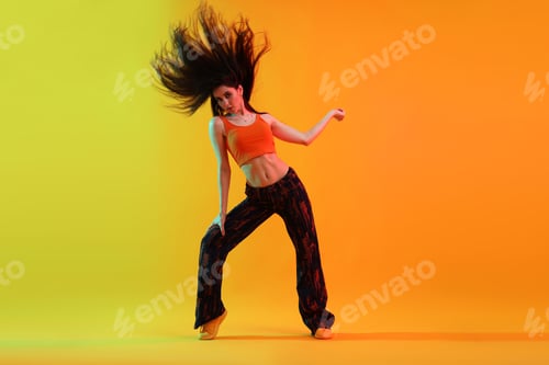 Preview: Young woman performing hip-hop dance on color background