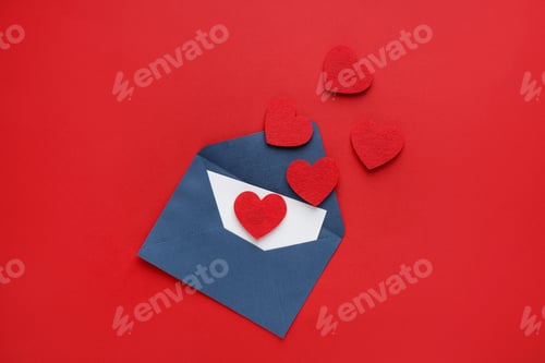 Preview: Happy Valentine's day. Envelope with greeting card and decorative hearts on red background, flat lay