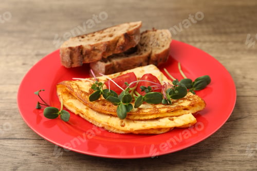 Preview: Tasty breakfast with omelette, microgreens, tomatoes and bread on wooden table, closeup