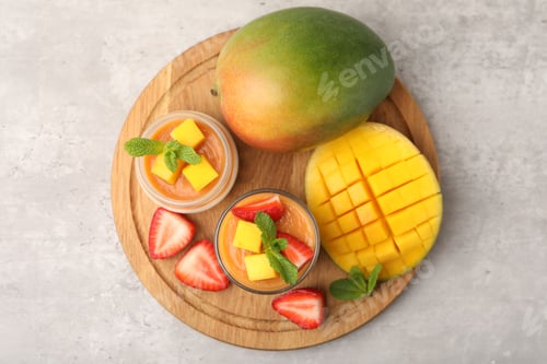 Preview: Delicious mango panna cotta, fruits and mint on grey table, top view