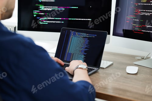Preview: Programmer working with laptop at desk in office, closeup