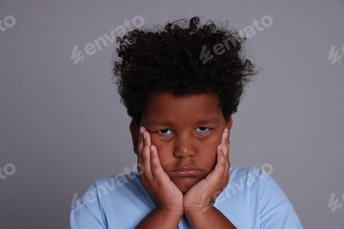 Preview: Portrait of resentful little boy on grey background
