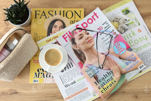 Preview: Lifestyle magazines, glasses and cup of coffee on wooden table, flat lay