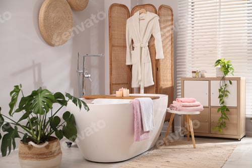 Preview: Stylish bathroom with bath tub, towels and houseplants