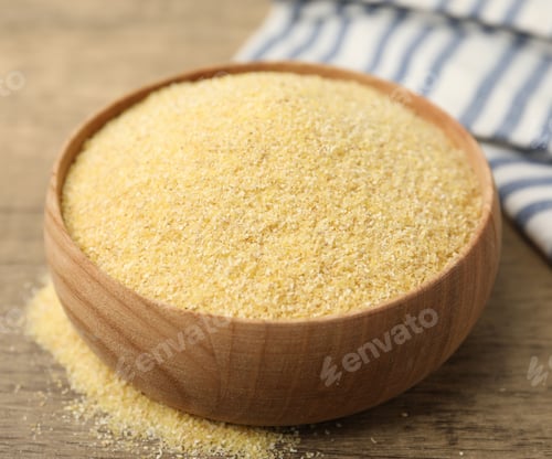 Preview: Raw semolina in bowl on wooden table, closeup