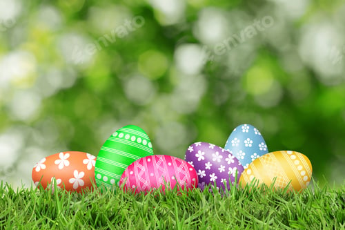 Preview: Easter eggs in green grass against blurred background