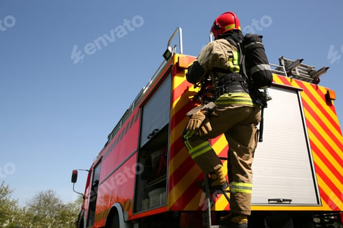 Preview: Firefighter in uniform on fire truck outdoors, back view