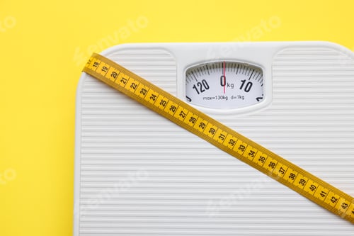Preview: Scales with measuring tape on yellow background, top view