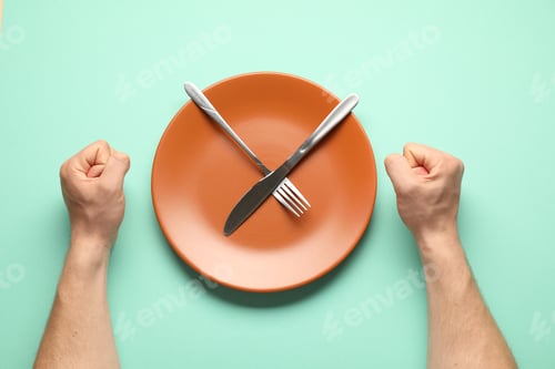 Preview: Man with cutlery and plate on turquoise background, top view
