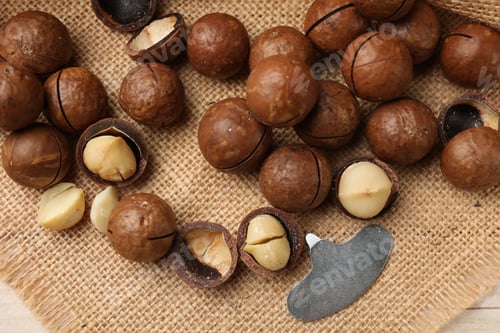 Preview: Macadamia nuts and metal key on light table, top view