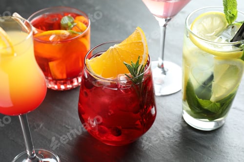 Preview: Different tasty refreshing cocktails on grey table, closeup