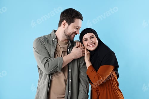 Preview: Portrait of happy muslim couple on light blue background