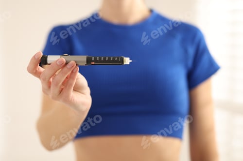 Preview: Diabetes. Woman with autoinjector at home, closeup