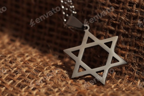 Preview: Holocaust Remembrance Day. Pendant in shape of Star of David on burlap cloth, closeup