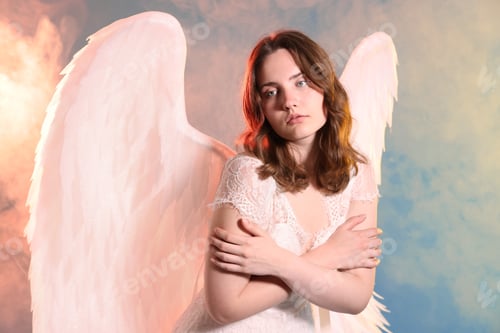 Preview: Beautiful girl dressed as angel on light blue background with smoke