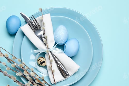 Preview: Easter celebration. Festive table setting with willow branches and painted eggs on light blue backgr
