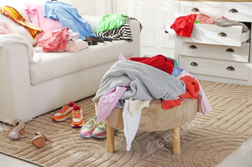 Preview: Many different messy clothes on furniture in room