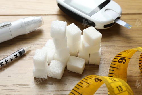 Preview: Diabetes control. Digital glucometer, sugar, syringe, lancet pen and measuring tape on wooden table,