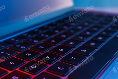 Preview: Stylish modern laptop in neon lights, closeup