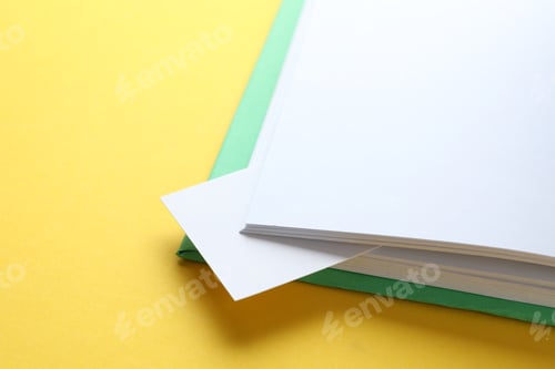 Preview: Book with white bookmark on yellow background, closeup. Space for text