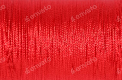 Preview: Spool of red sewing thread as background, closeup