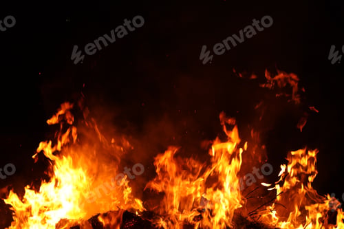Preview: Large bright bonfire burning against black background